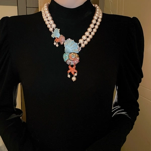 Detail of double-layer pearl necklace with rhinestone shell, conch, and starfish charms
