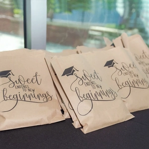 Brown kraft paper graduation gift bags with black Sweet Endings print and cap icon