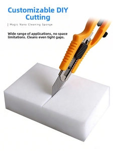 Macro shot of a hand cutting a white nano cleaning sponge with a utility knife for DIY size