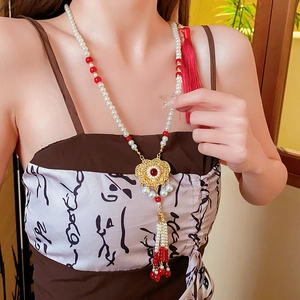 Detail of Chinese Phoenix Lock necklace with pearls, red beads, and golden tassel