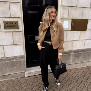 Chic urban street style featuring a camel wool varsity jacket with contrast details
