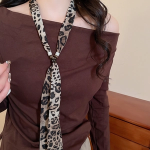 Detail of leopard print chiffon scarf necklace with dark buckle on a model's neck