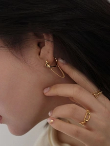 Detail shot of 925 silver knot earrings with long gold chains and matching rings
