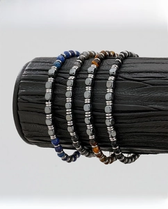 Macro shot of men's beaded bracelets in tiger eye and lapis lazuli on leather display