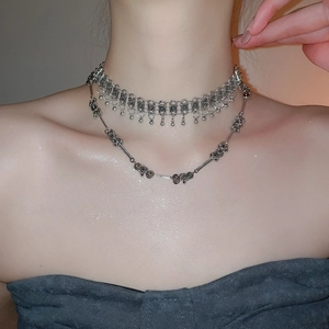 Detail of bohemian layered choker necklace with metallic beads and spiral accents