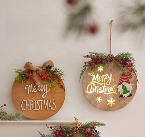 Close-up of wooden Christmas hanging sign with warm lights and festive pine decorations