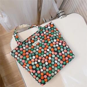 Detailed top view of a colorful polka dot cotton tote bag with sturdy handles
