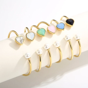 Gold open ring set with colorful heart stones and pearls displayed on white stands