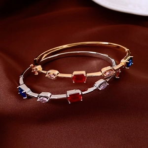 Detail of 18K gold and silver plated vintage bangles with colorful emerald-cut gemstones