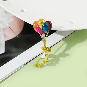 Détail de l'épingle émaillée grenouille avec ballons colorés sur plateau en céramique