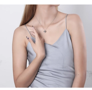 Close-up of a silver crown necklace pendant on a model with elegant silk attire