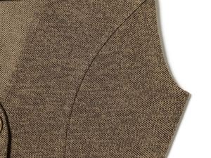 Close-up of brown textured fabric with button detail on a sleeveless V-neck dress