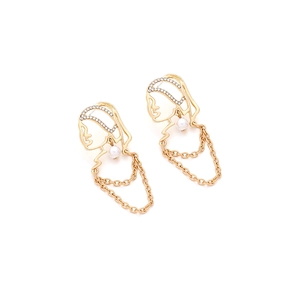 Close-up of golden face profile earrings with sparkling rhinestones and elegant tassels