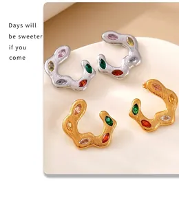 Macro detail of 18k gold and silver C-shaped earrings with vibrant colorful zircons