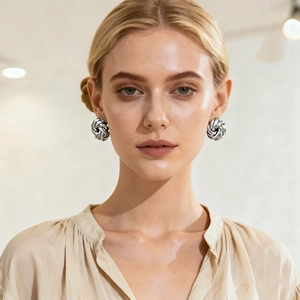 Minimalist metallic vortex flower earrings in silver finish worn by a model
