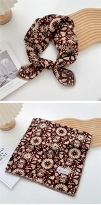 Detail of coffee brown floral cotton linen scarf with beige lace edges and knot style
