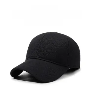 Close-up of black winter baseball cap showing thick textured fabric and silver metal badge