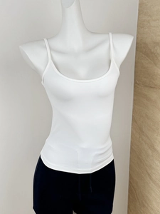 Detailed close-up of white slim-fit tank top texture and minimalist shoulder strap design