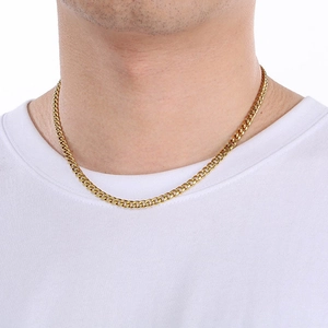 Classic 18K gold stainless steel Cuban chain necklace worn by a model on a white tee