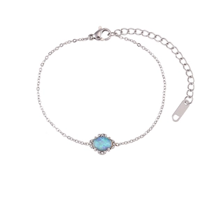 Bracelet chaîne en argent avec opale bleue ovale et strass sur un fond blanc épuré