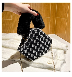 Detail of hexagonal jacquard bag with black faux fur handle and gold chain strap