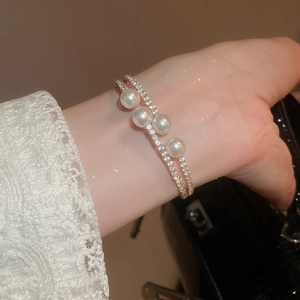 Détail macro d'un luxueux bracelet en or à double rangée avec perles et pavé de diamants