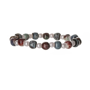Close-up of handmade ceramic beads with colorful kiln-glaze texture on a boho bracelet
