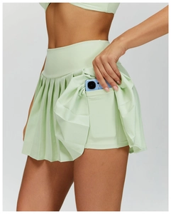 Detail of light green pleated tennis skort featuring functional side pocket on inner lining