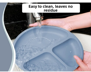 Water rinsing a grey-blue silicone toddler plate to show its easy-to-clean surface