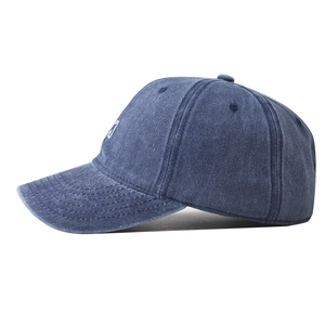 Détail de la broderie blanche sur casquette en coton lavé bleu foncé au style vintage