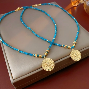 Detailed close-up of two ethnic blue beaded necklaces with golden evil eye pendants