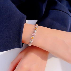 Luxurious multi-color gemstone bracelet with micro-pave diamonds on model's wrist