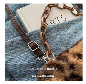 Detail of leopard print plush bag with adjustable leather strap and acrylic chain link