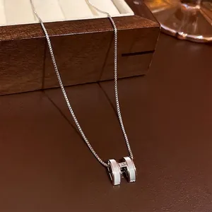 Minimalistische silberne H-Buchstaben-Halskette mit weißem Inlay auf Schmuckkästchen