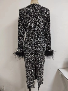 Détail des paillettes sur robe noire à manches longues et poignets en plumes d'autruche