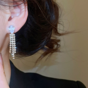 Vista dettagliata di eleganti orecchini a goccia con lunghe nappe scintillanti su modella