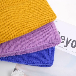 Unisex winter knit beanies in yellow, purple, and blue featuring thick ribbed texture
