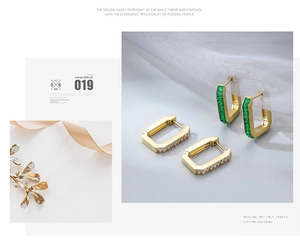 Detailed macro of gold geometric earrings with green and white baguette-cut stones