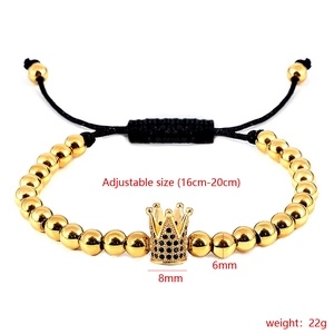 Detail view of adjustable gold beaded bracelet with crown charm and black zircons