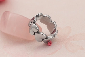 Macro detail of continuous heart-shaped silver rings on a pink decorative background