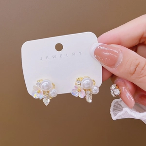 Detail shot of French style floral pearl earrings with zircon accents on jewelry card