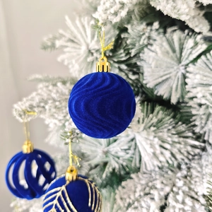 Gros plan de boules de Noël en velours bleu floqué avec des textures de vagues