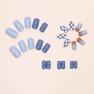 Detail of short square press-on nails in blue checkerboard and brown smudge design