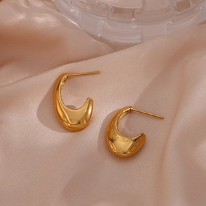 Polished gold teardrop hollow earrings on champagne silk background for women