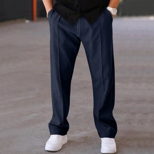 Detail of navy blue relaxed-fit trousers showing elastic drawstring waist and pleated front