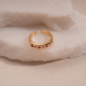 Detail of gold open ring with pink and purple rhinestones on mineral stones