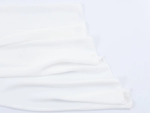 Détail de la texture légère du tissu en mousseline blanche et du drapé doux sur le haut