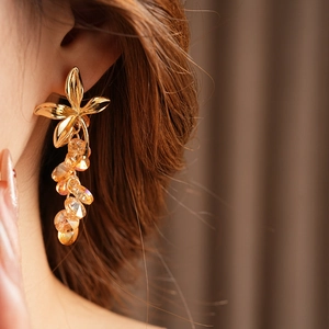 Detail of vintage flower stud earrings with cascading orange crystal bead tassels