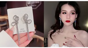 Detail of silver bow tassel earrings with S925 needles and pearl accents on model