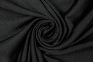 Detail of high-quality black knit fabric showing spiral pleats and soft texture